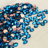 Assorted cobalt blue faceted rhinestones with rose-gold backs on light surface