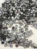 Loose round faceted crystal stones in dark gray and clear tones, mixed sizes