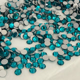 Assorted teal crystal chatons (no hotfix), round faceted stones in a pile