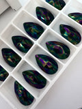 Tray of teardrop sew-on crystal stones in dark rainbow iridescence, multiple holes visible