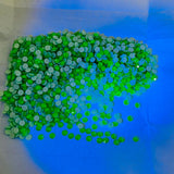 Swarovski crystal article 2088 XIRIUS Rose flat back stones in Electric Green, shown under UV, black light to show luminescence and glow in the dark capabilities