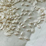 Pearl-white hotfix navette crystal stones, glossy leaf-shaped cabochons on paper