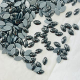 Jet hematite hotfix navette cabochon crystals, tightly scattered dark metallic ovals on backing