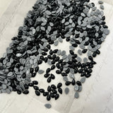 Jet black and silver pear-shaped hotfix cabochon crystals, drop style on white backing.