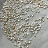 Pear-shaped pearl white hotfix crystal drops close-up on backing sheet